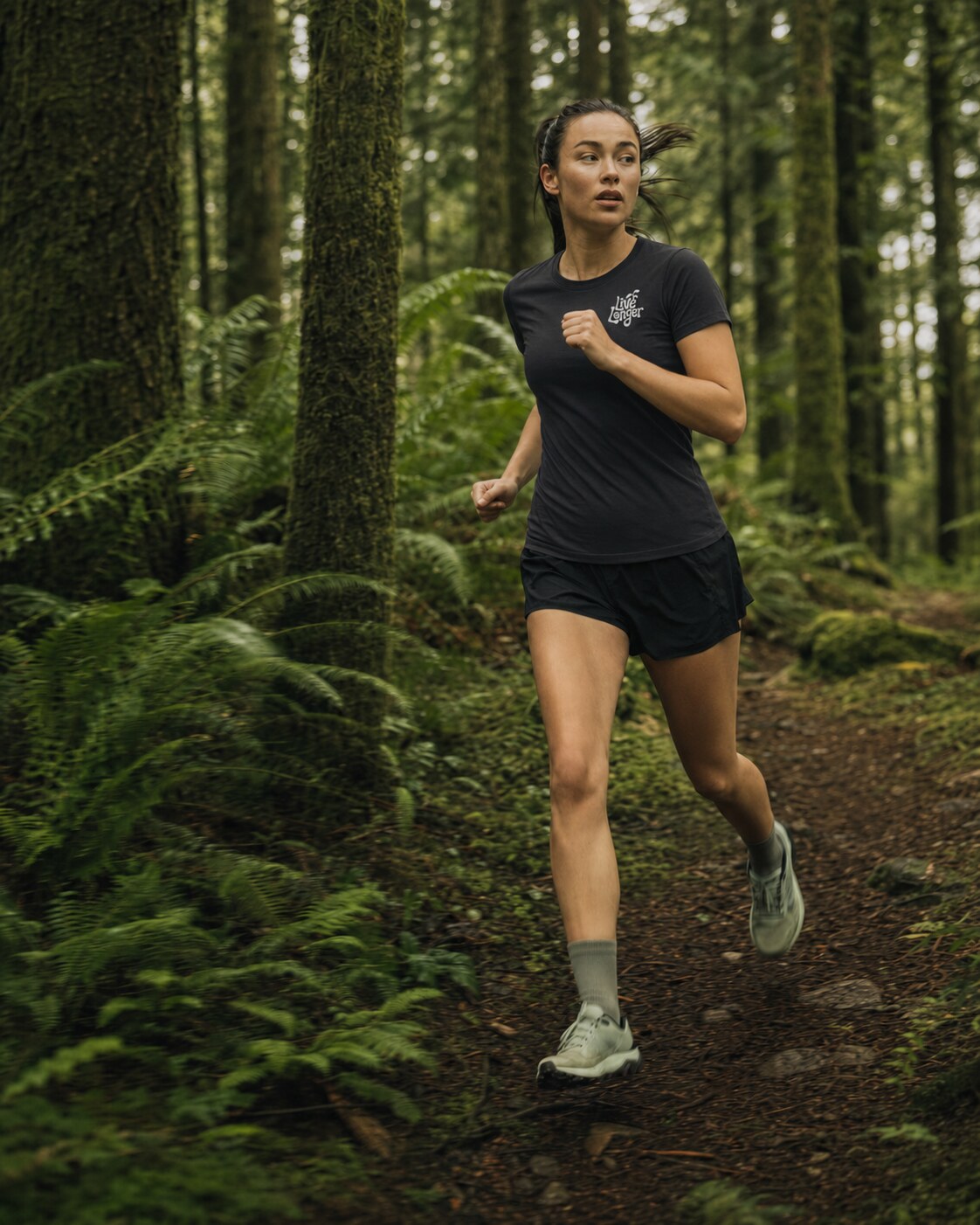 Trail runner wearing a black Live Longer T-shirt in an evergreen forest